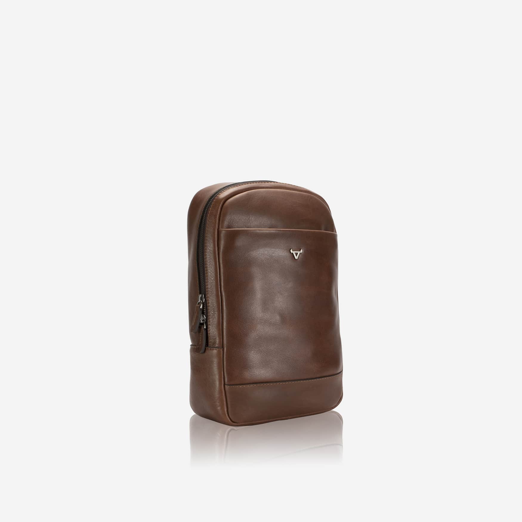 Brosnan One Strap Backpack in brown, angled view showing side zip and slim profile
