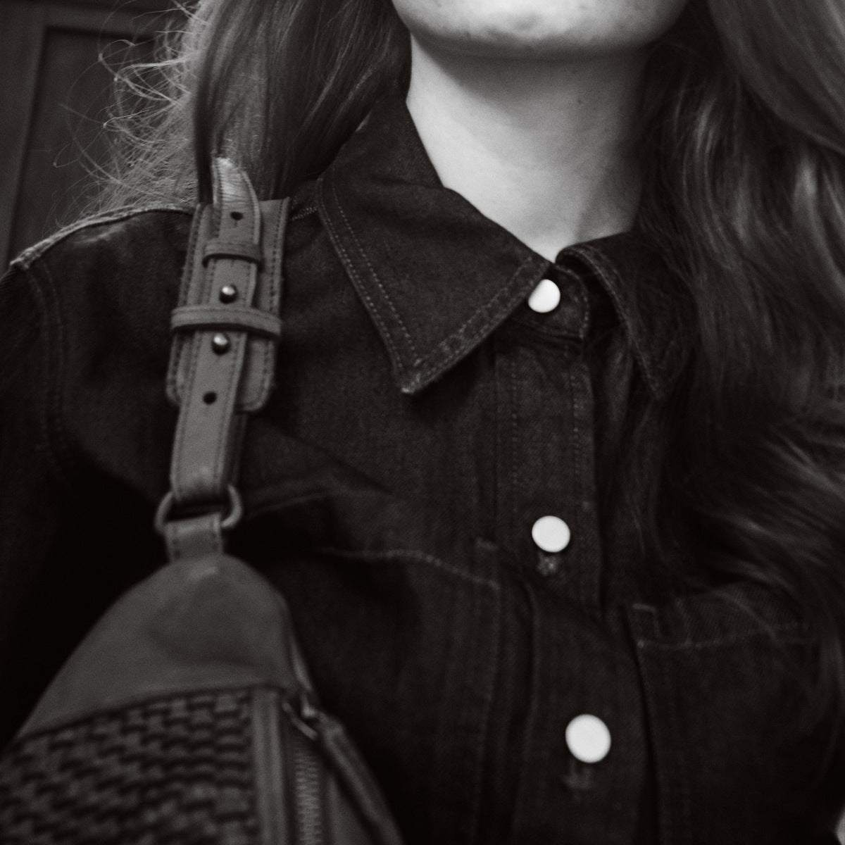 Black and white close-up of the Bell Waist Bag strap buckle and woven leather against denim