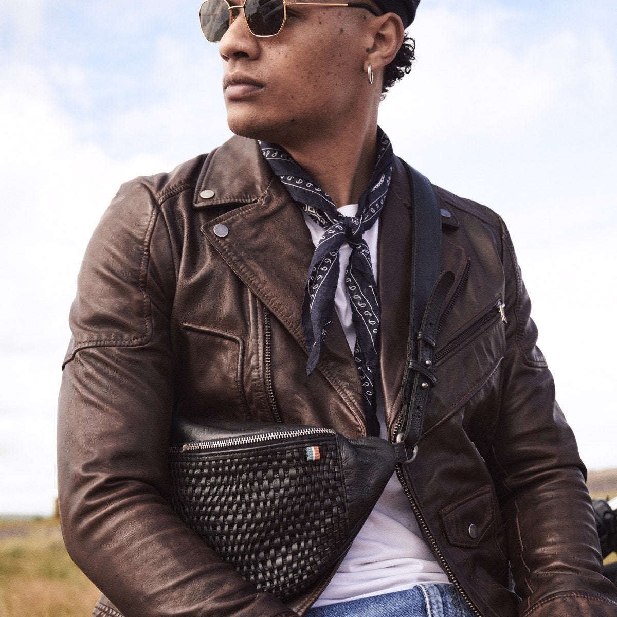 Man in sunglasses and a bandana wearing the black Bell Waist Bag over a leather jacket