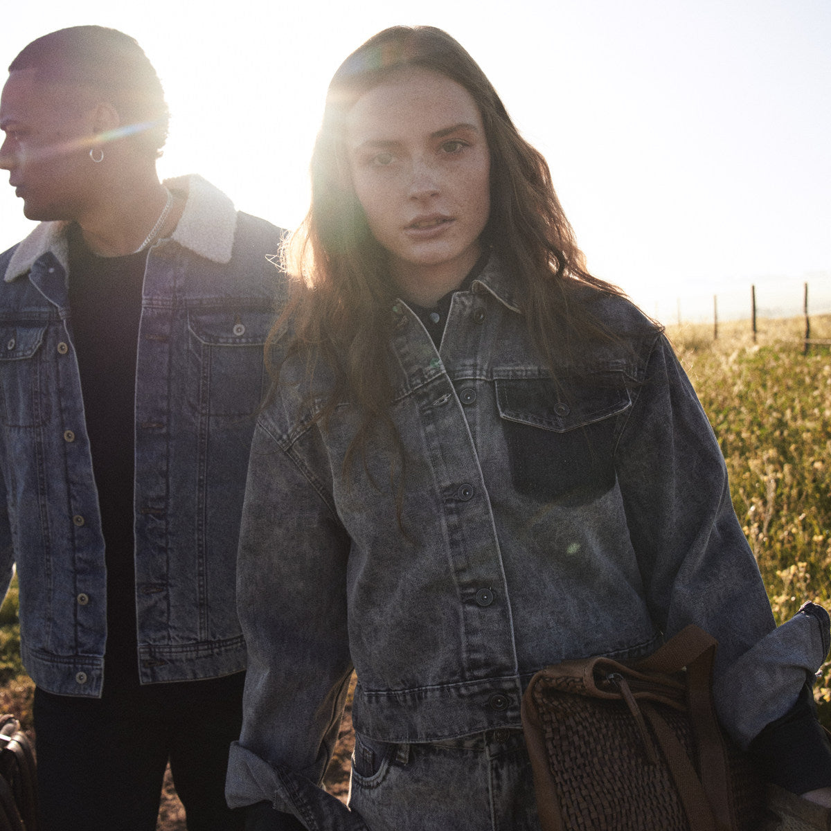 Cognac Bell Shopper held at the hip, couple in denim backlit in a field