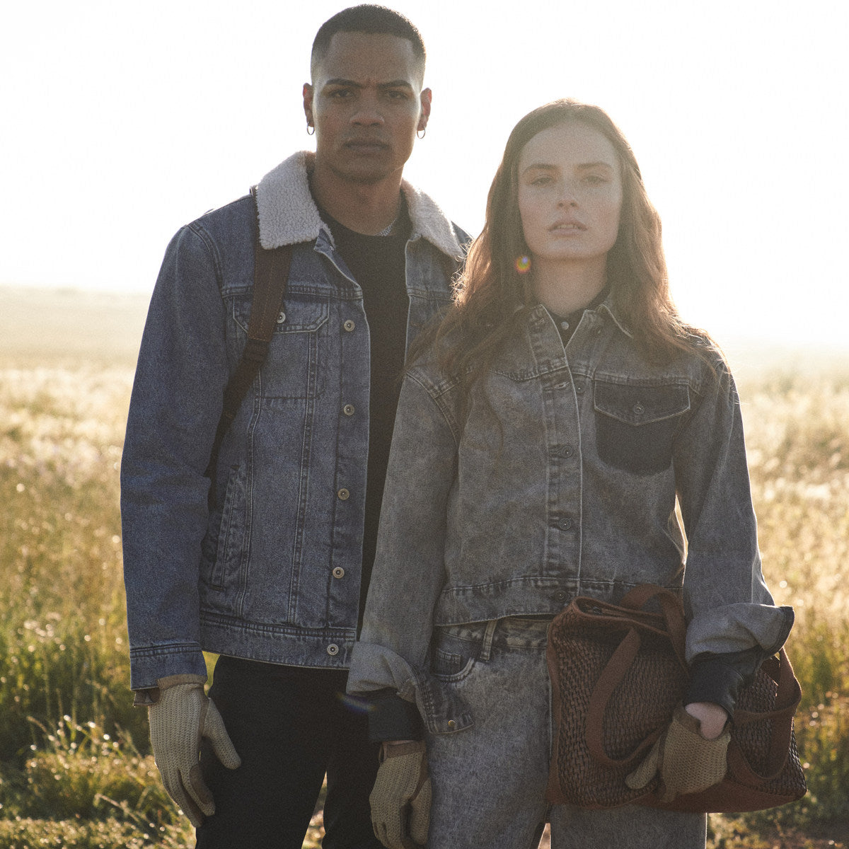 Woman in washed denim holding the cognac Bell Shopper beside a man in a sherpa jacket